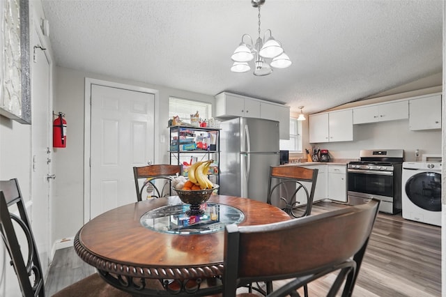 dining room with a textured ceiling, washer / dryer, light wood finished floors, and a notable chandelier
