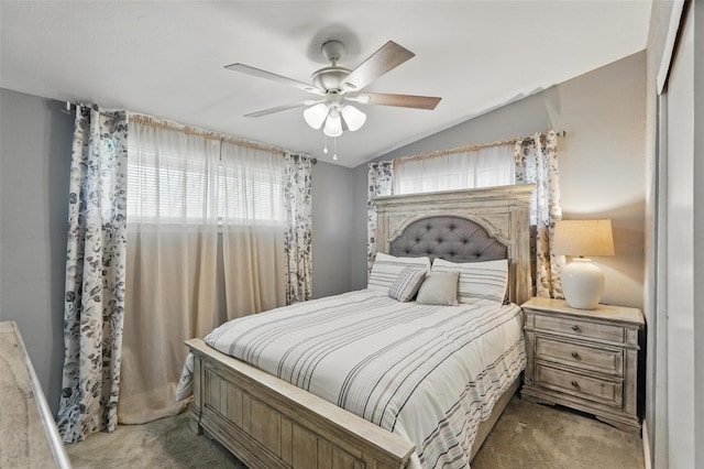 carpeted bedroom with ceiling fan and vaulted ceiling