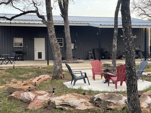 rear view of property with metal roof and a patio area