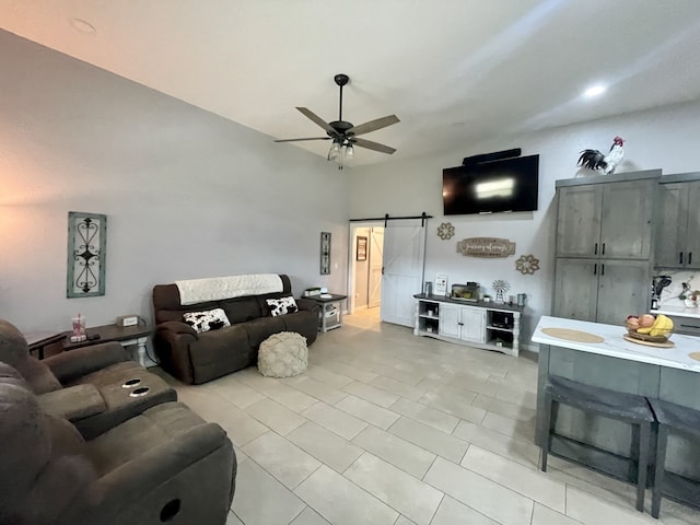 living room with light tile patterned flooring, a barn door, and a ceiling fan