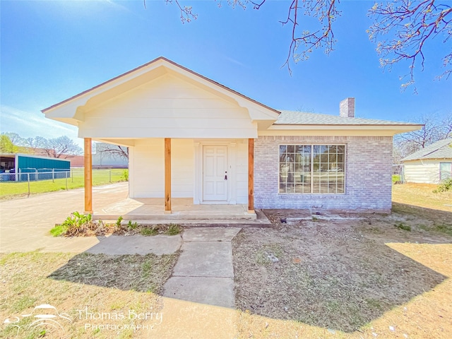 210 Wise St, Clyde, TX 79510 - bungalow-style house with fence, a chimney, a porch, and brick siding