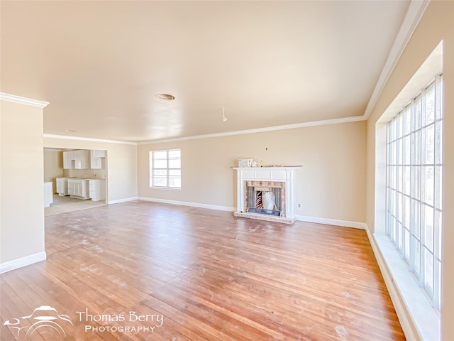 210 Wise St, Clyde, TX 79510 - unfurnished living room featuring baseboards, light wood-type flooring, crown molding, and a brick fireplace