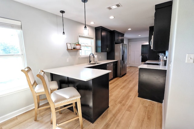 2432 Cottondale Rd, Springtown, TX 76082 - kitchen featuring a sink, appliances with stainless steel finishes, light countertops, a peninsula, and a kitchen bar
