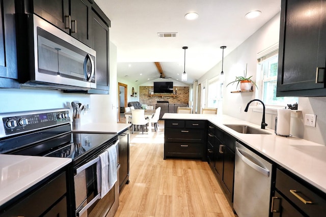 2432 Cottondale Rd, Springtown, TX 76082 - kitchen with stainless steel appliances, a sink, light wood finished floors, light countertops, and open floor plan