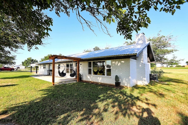 2432 Cottondale Rd, Springtown, TX 76082 - back of house featuring a patio, a yard, brick siding, a chimney, and metal roof