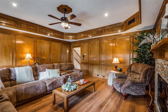 2505 Skipwith Dr, Plano, TX 75023 - living area with a textured ceiling, wood walls, ceiling fan, and stairs