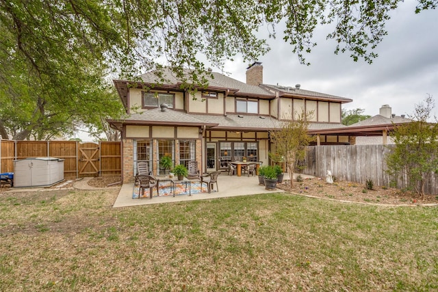 2505 Skipwith Dr, Plano, TX 75023 - rear view of house with a patio, a gate, a chimney, a lawn, and a fenced backyard