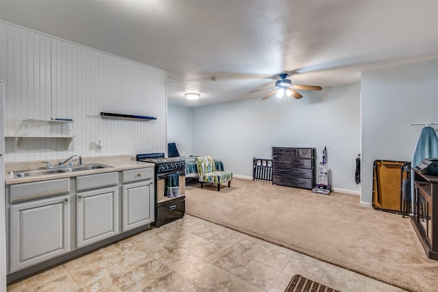 3929 Collinwood Ave, Fort Worth, TX 76107 - kitchen with black gas range, a sink, light colored carpet, gray cabinets, and a ceiling fan