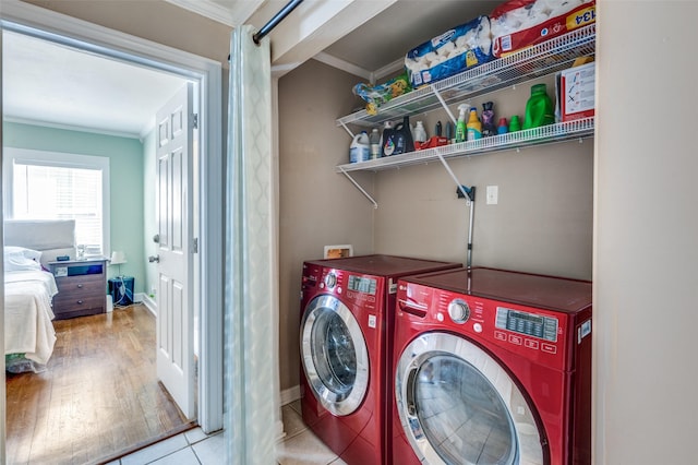 3929 Collinwood Ave, Fort Worth, TX 76107 - clothes washing area with washer and dryer, ornamental molding, baseboards, and wood finished floors