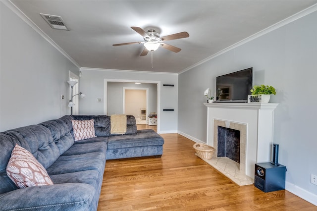 3929 Collinwood Ave, Fort Worth, TX 76107 - living area with a ceiling fan, light wood finished floors, a tiled fireplace, crown molding, and baseboards