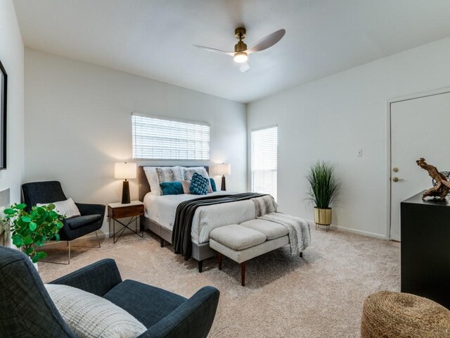 bedroom featuring light carpet, baseboards, and ceiling fan
