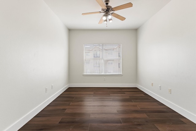 empty room with dark wood-type flooring, a ceiling fan, and baseboards