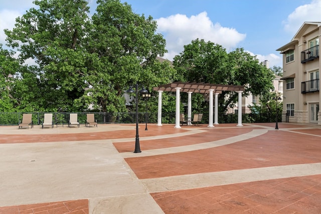 view of home's community with fence and a pergola