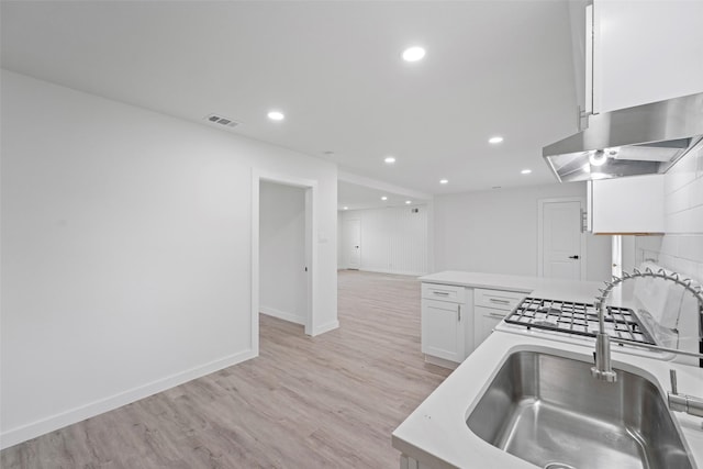11534 Fernald Ave, Dallas, TX 75218 - kitchen featuring a sink, under cabinet range hood, white cabinets, recessed lighting, and light wood finished floors