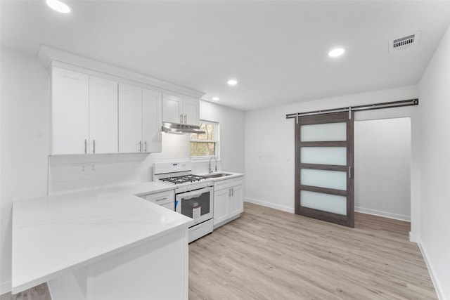 11534 Fernald Ave, Dallas, TX 75218 - kitchen featuring white gas range oven, under cabinet range hood, a sink, white cabinetry, and light countertops