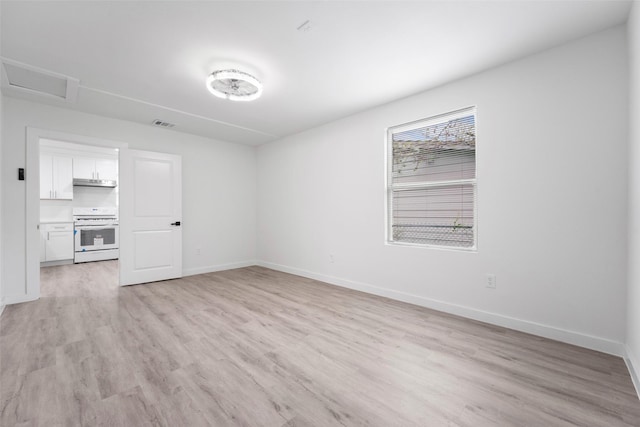 11534 Fernald Ave, Dallas, TX 75218 - unfurnished living room with light wood-style floors, baseboards, and attic access