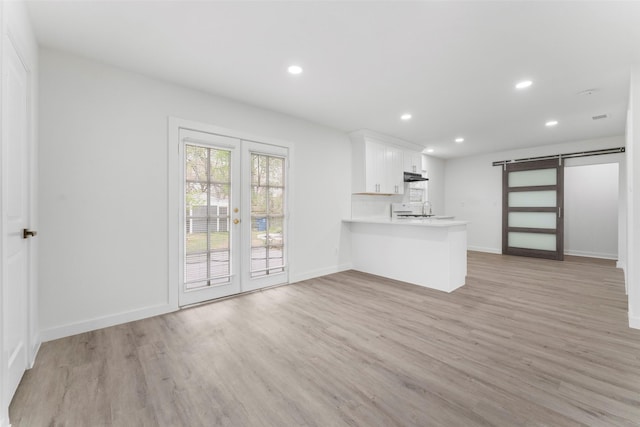 11534 Fernald Ave, Dallas, TX 75218 - unfurnished living room with light wood finished floors, french doors, recessed lighting, baseboards, and a barn door