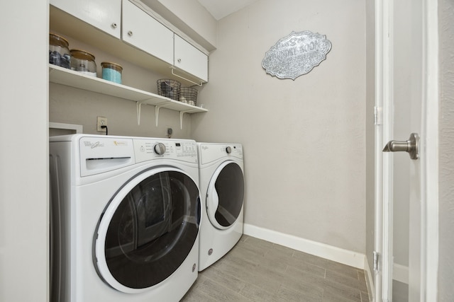 1225 Dumont Dr, Richardson, TX 75080 - washroom with washing machine and clothes dryer, baseboards, cabinet space, and light wood-style floors