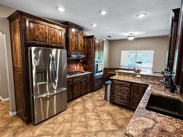 300 Cleve Cole Rd, Denison, TX 75021 - kitchen featuring appliances with stainless steel finishes, dark brown cabinets, light tile patterned floors, recessed lighting, and decorative backsplash