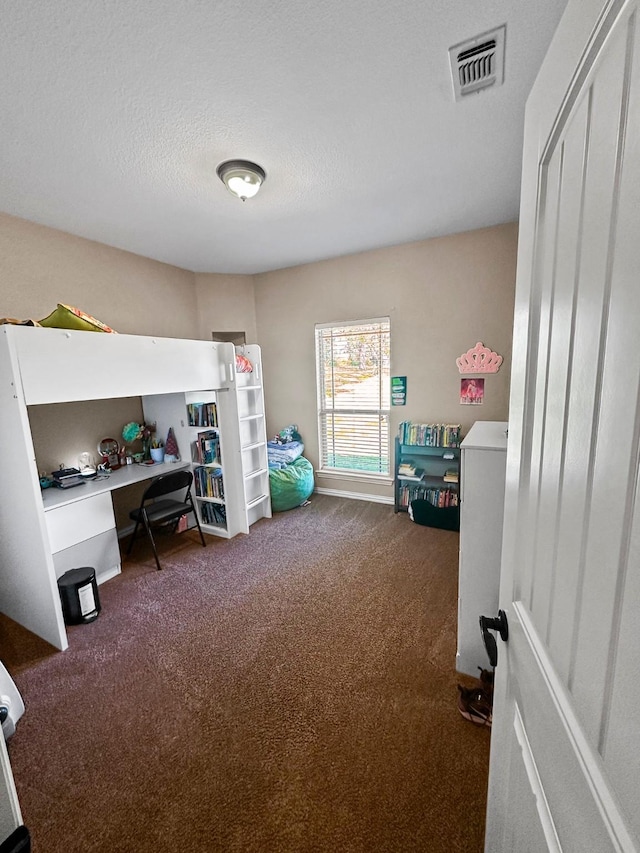 bedroom featuring carpet flooring, an office area, and a textured ceiling