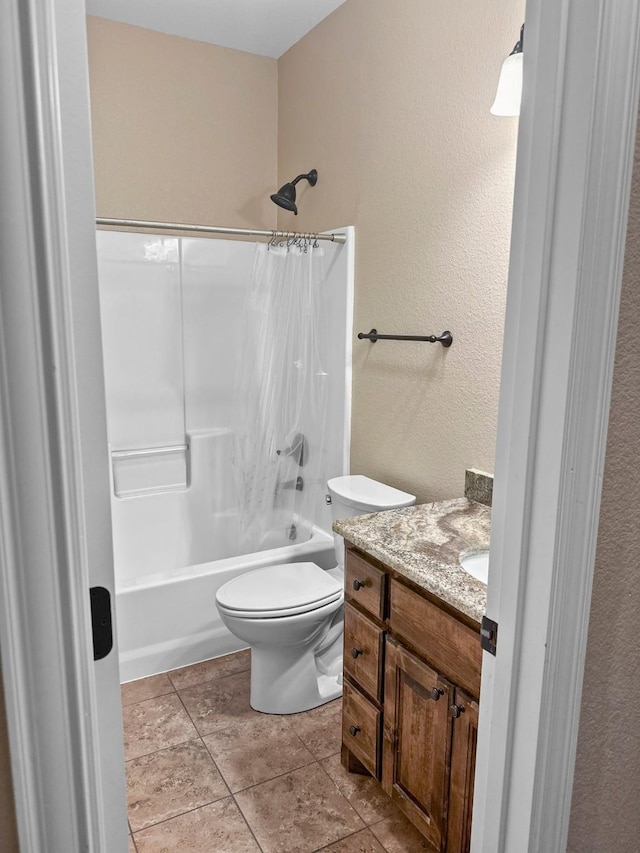bathroom with shower / bathtub combination with curtain, vanity, toilet, a textured wall, and tile patterned floors