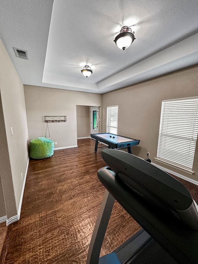 playroom with a textured ceiling, baseboards, a tray ceiling, and carpet flooring
