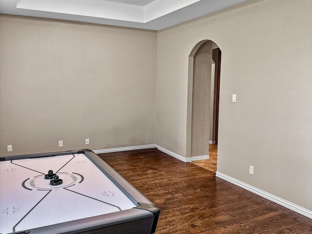 300 Cleve Cole Rd, Denison, TX 75021 - empty room with arched walkways, wood finished floors, baseboards, and a raised ceiling