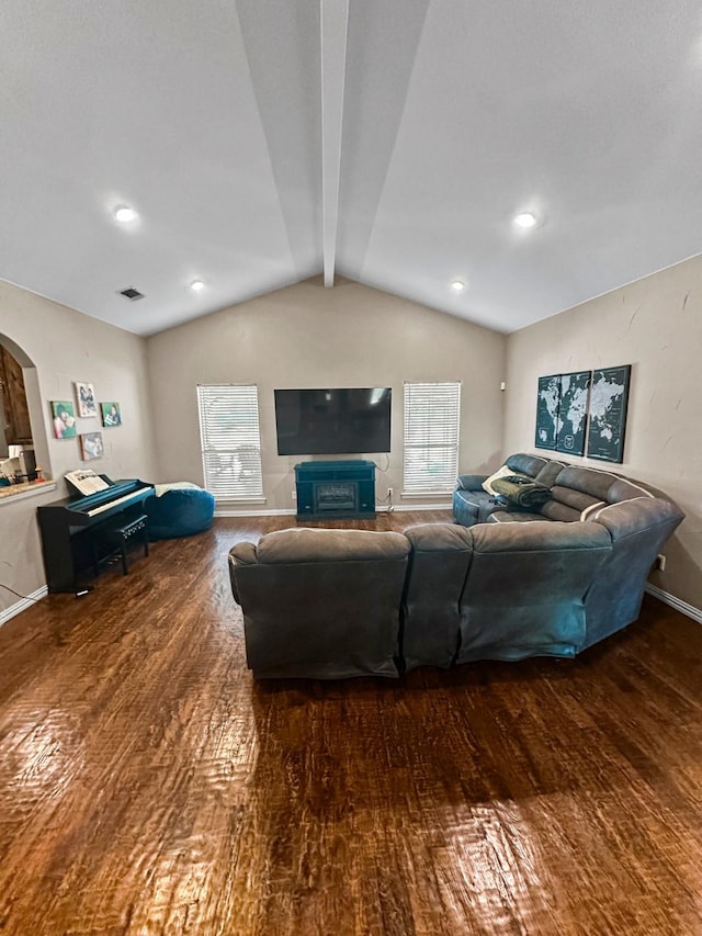 living room with wood finished floors, arched walkways, and baseboards