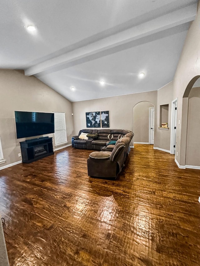 living room with arched walkways, wood finished floors, and baseboards