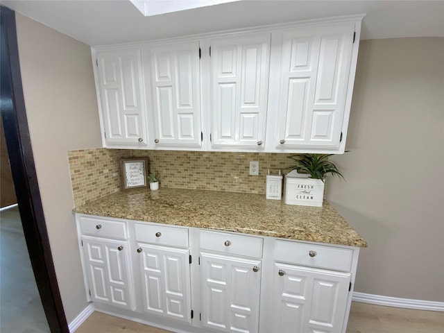 1332 Burmeister Rd, Fort Worth, TX 76134 - kitchen featuring white cabinetry, light stone counters, and decorative backsplash