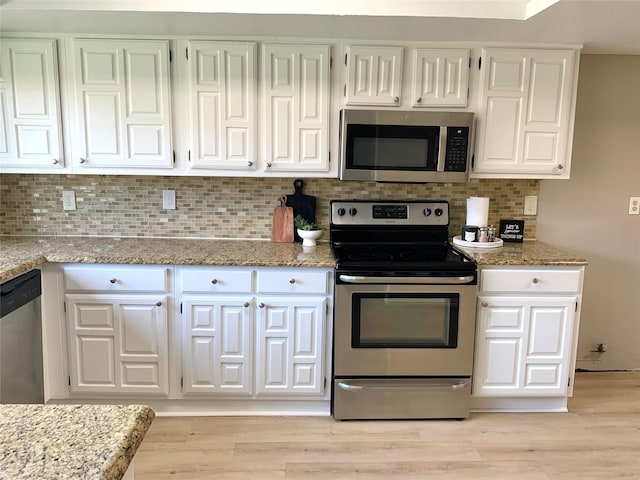 1332 Burmeister Rd, Fort Worth, TX 76134 - kitchen with white cabinetry, stainless steel appliances, decorative backsplash, light stone counters, and light wood finished floors