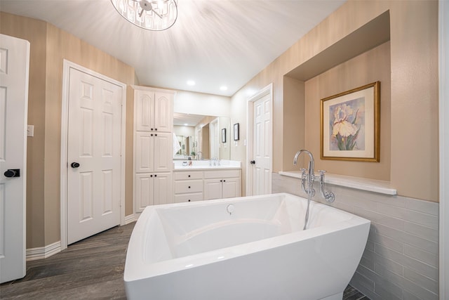 1022 High Meadow Dr, Mount Vernon, TX 75457 - bathroom with a soaking tub, vanity, and wood finished floors