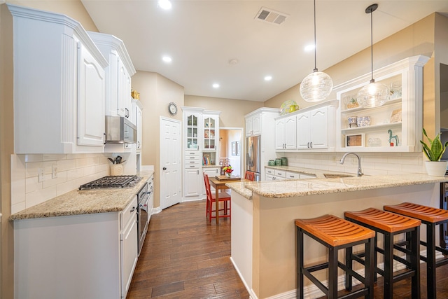 1022 High Meadow Dr, Mount Vernon, TX 75457 - kitchen featuring visible vents, a peninsula, stainless steel appliances, a sink, and a kitchen breakfast bar