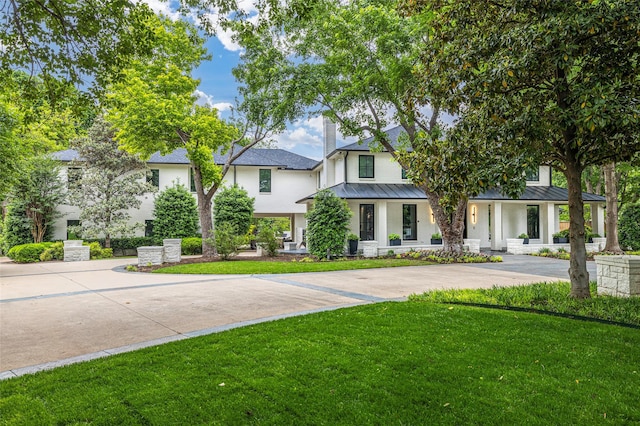 3512 Willow Bend Dr, Plano, TX 75093 - view of front of home featuring a standing seam roof, metal roof, a front lawn, and stucco siding