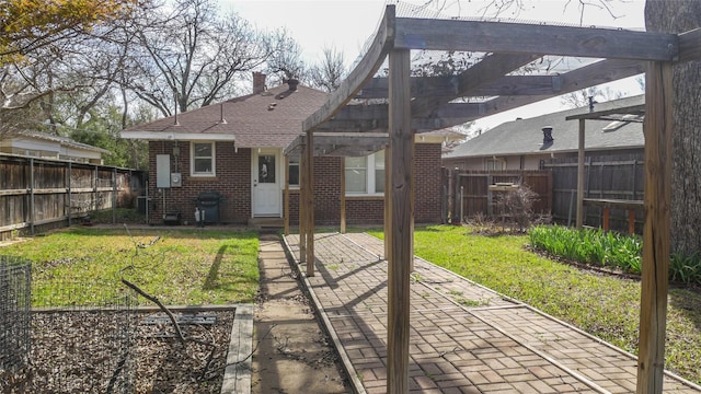 rear view of house with a patio area, a pergola, a yard, brick siding, and a fenced backyard