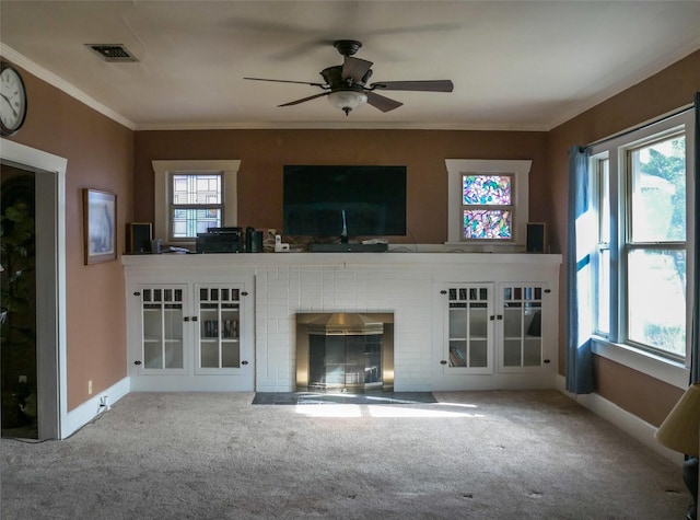 unfurnished living room featuring a wealth of natural light, a ceiling fan, carpet flooring, and crown molding