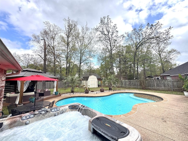 view of pool with an outbuilding, a fenced backyard, a patio, and a shed