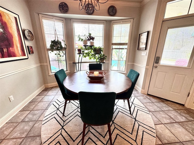 dining space with a chandelier, crown molding, and baseboards