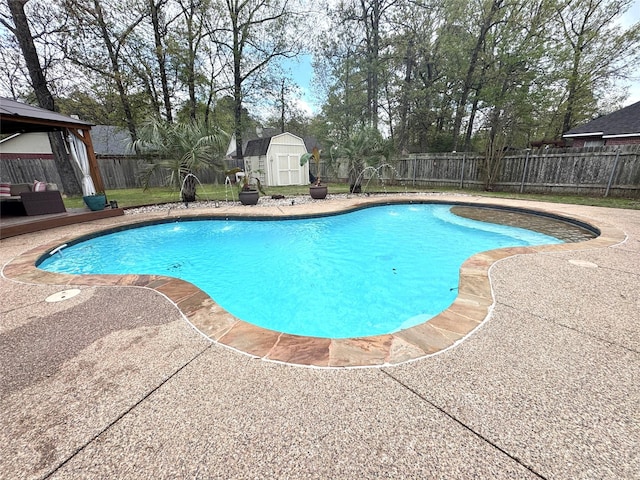view of swimming pool with a fenced backyard, an outdoor structure, a patio area, a storage unit, and a fenced in pool