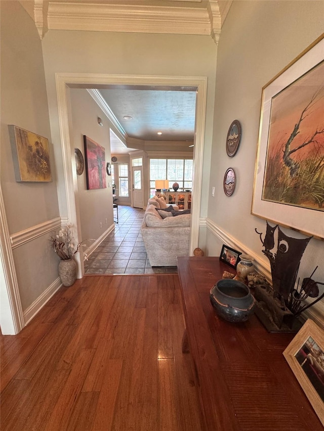 hallway featuring crown molding, wood finished floors, and baseboards