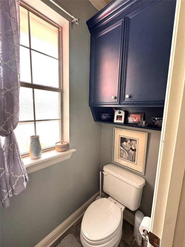 bathroom with baseboards and toilet