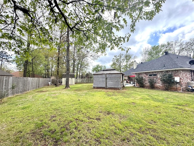 view of yard with an outbuilding, a fenced backyard, and a storage shed