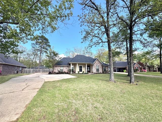 ranch-style house with driveway, a front yard, and fence