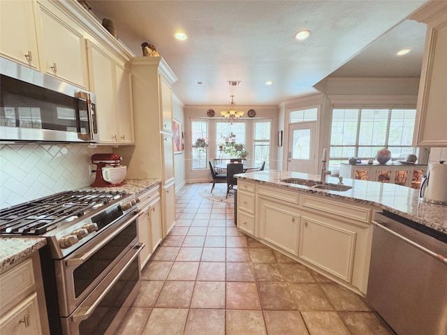 kitchen with an inviting chandelier, tasteful backsplash, ornamental molding, a sink, and stainless steel appliances