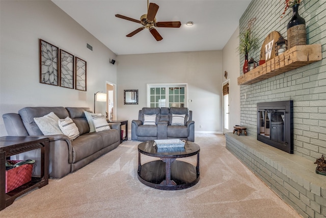 328 S Jackson Ave, Justin, TX 76247 - carpeted living area featuring ceiling fan, a brick fireplace, a towering ceiling, and baseboards
