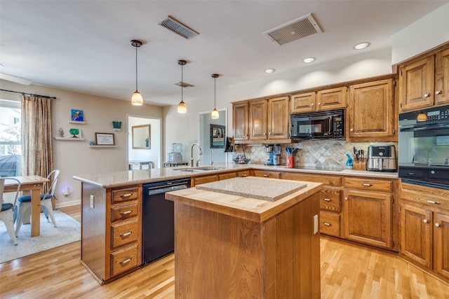 328 S Jackson Ave, Justin, TX 76247 - kitchen with black appliances, a sink, a kitchen island, wooden counters, and a peninsula