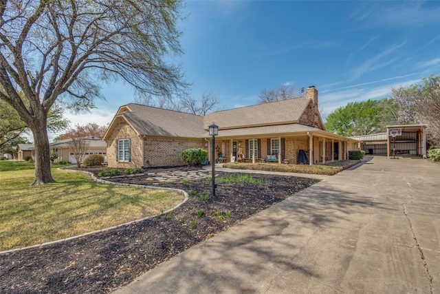 328 S Jackson Ave, Justin, TX 76247 - view of front of home featuring brick siding, concrete driveway, a chimney, and a front lawn