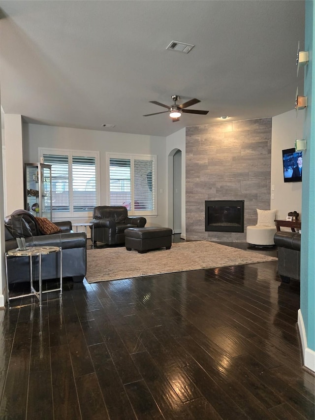1214 Norwood St, Mansfield, TX 76063 - living area featuring ceiling fan, visible vents, arched walkways, hardwood / wood-style flooring, and a tile fireplace