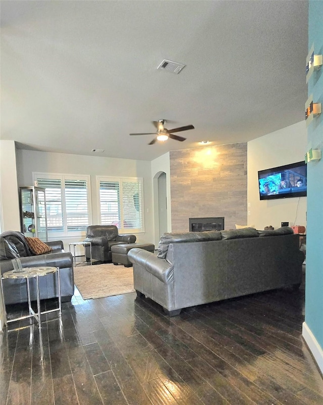 1214 Norwood St, Mansfield, TX 76063 - living area with visible vents, ceiling fan, wooden walls, dark wood-style floors, and a tiled fireplace