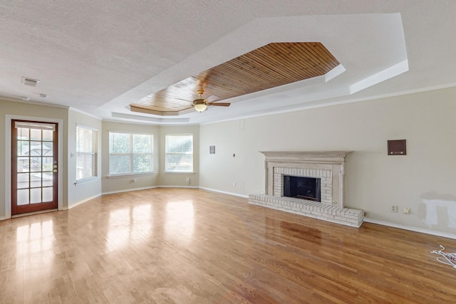 102 Cedar Dr, Oak Leaf, TX 75154 - unfurnished living room featuring a tray ceiling, visible vents, plenty of natural light, and wood finished floors